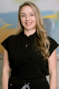 Friendly woman with clear skin, blue eyes, and blonde hair.